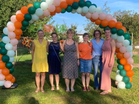 sechs Personen in einem Rahmen von Luftballons